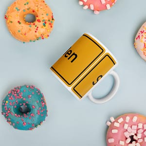 Eine glänzende Tasse mit Donuts und einem Schild.