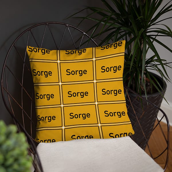 Ein gelber Basic-Kissen mit dem Schriftzug „Sorge“.