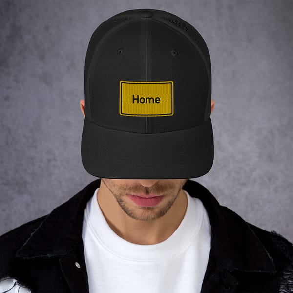 Ein Mann trägt eine Trucker-Cap mit der Aufschrift „Home“ darauf.