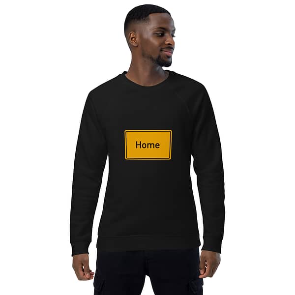 Ein Mann trägt einen Unisex-Bio-Raglan-Pullover mit der Aufschrift „Home“ darauf.