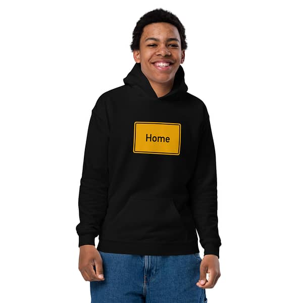 Ein jugendlicher Junge trägt einen Heavy-Blend Hoodie für Jugendliche mit dem Wort „home“ darauf.