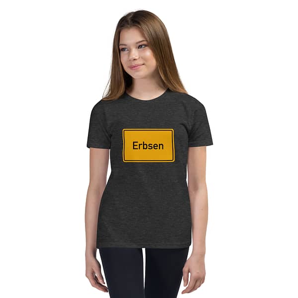 Ein Mädchen trägt ein kuzärmeliges T-Shirt für Kinder mit dem Wort „esen“ darauf.